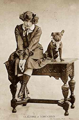 Colette and her bulldog Toby sit on a table together in a sepia-toned posed portrait