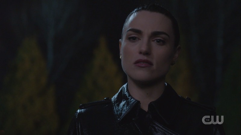Lena looks stern in a waterproof leather-looking rain trenchcoat??