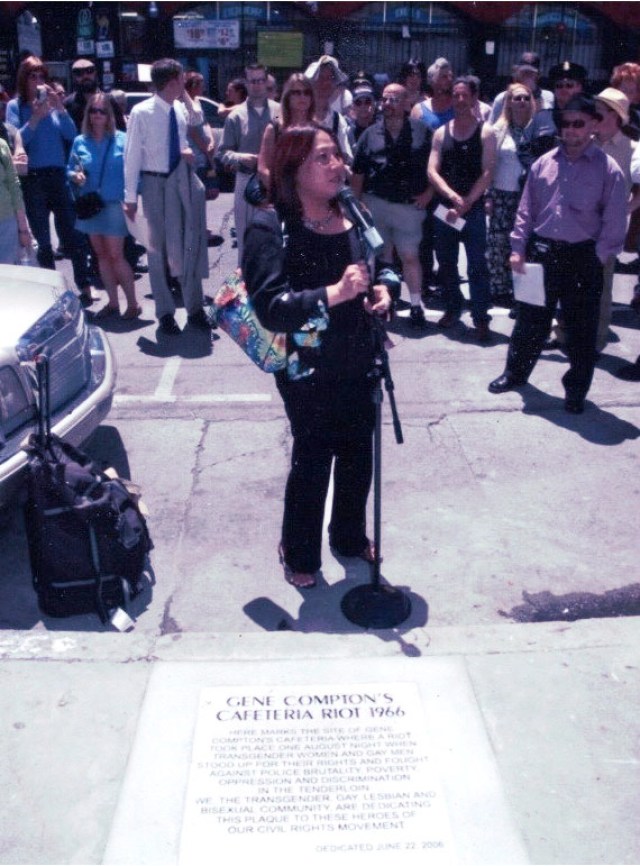 Cecilia organized and spoke at the 40th anniversary event for the Compton Cafeteria riots, which helped launch a national LGBTQ movement. Behind her stand a crowd of people.