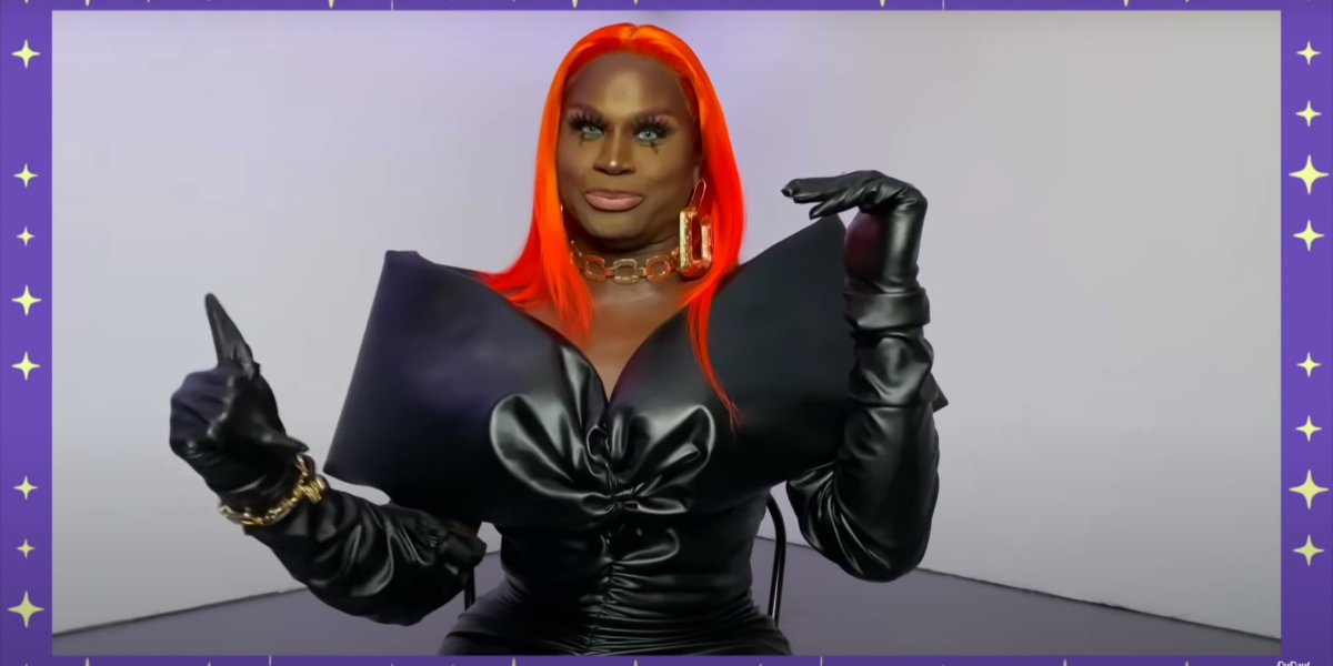 Drag Race 1325 Recap: LaLa Ri is wearing a leather dress with big shoulders, she has a bright orange wig