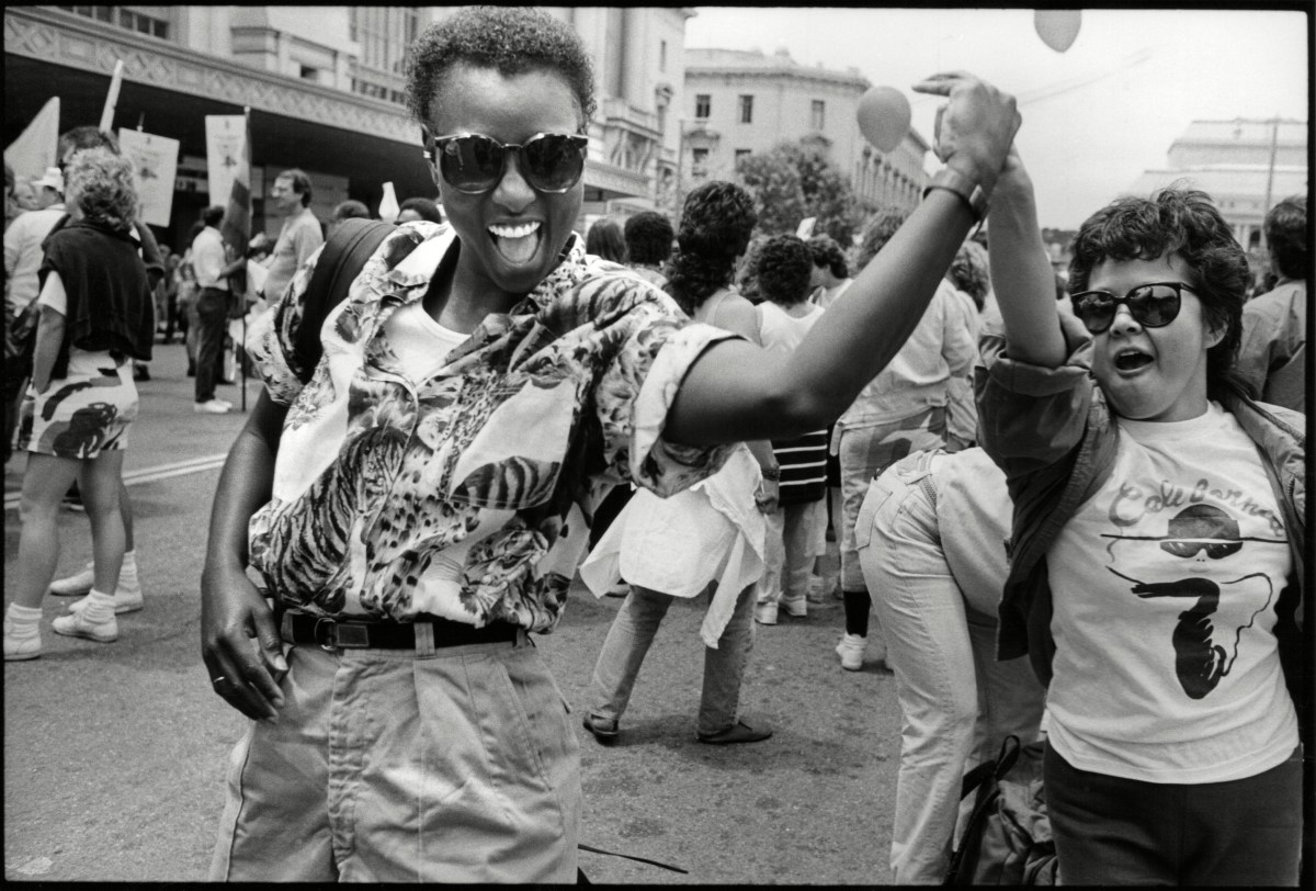 Two women hold hands as they dance outside the Civic Center during the International Lesbian & Gay Freedom Day Parade, San Francisco, California, June 28, 1987. 