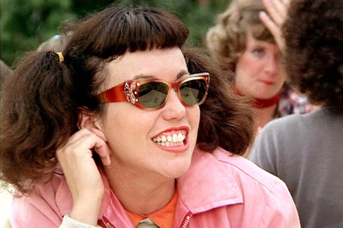 Jan in Grease, pigtails, pink jacket, sunglasses