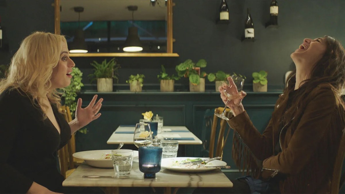 two women laughing at dinner