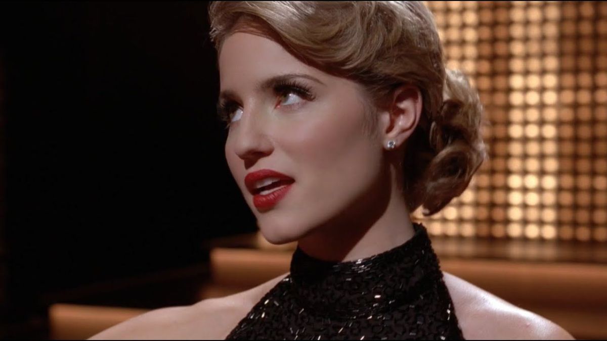 A close up of Quinn wearing a black strapless dress with her hair up
