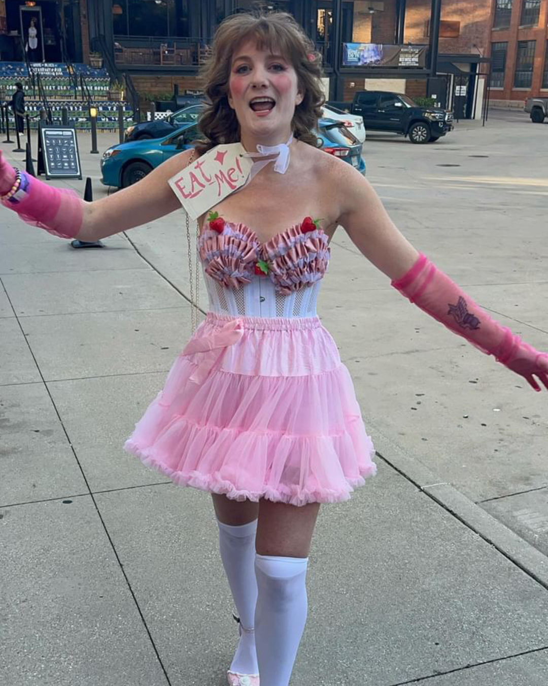 A Chappell fan wears a pink tutu and a sign that says EAT ME
