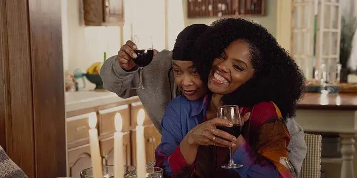 two Black women hugging in front of candles