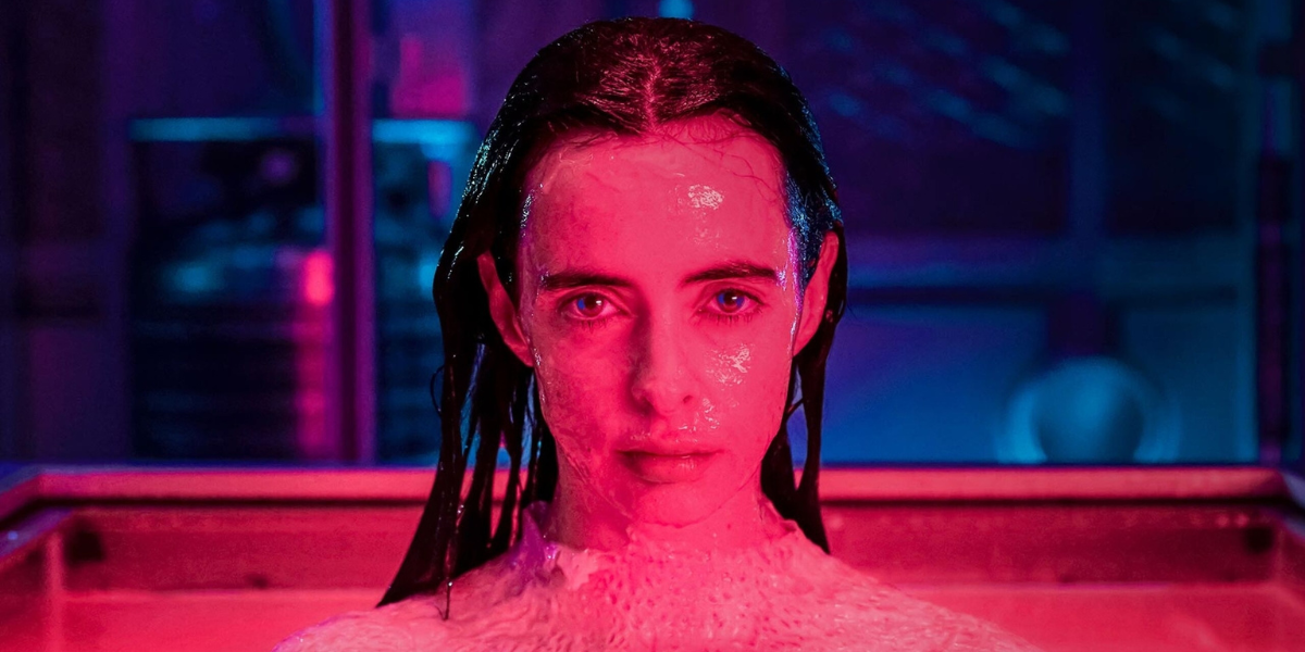 Orphan Black Echoes: a close up of Krysten Ritter wet in red lighting.