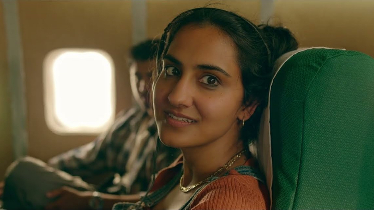 Best Lesbian Movies #100: a close up of Amrit Kaur sitting on a plane