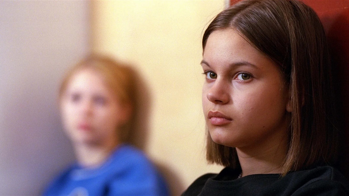 Best lesbian movies #20: two girls sit against a wall, one out of focus, one in focus.