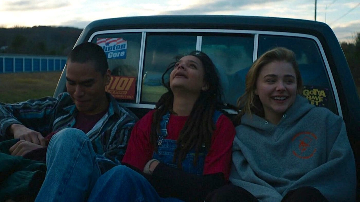 Forrest Goodluck, Sasha Lane, and Chloe Grace-Moretz smile in the back of a truck.
