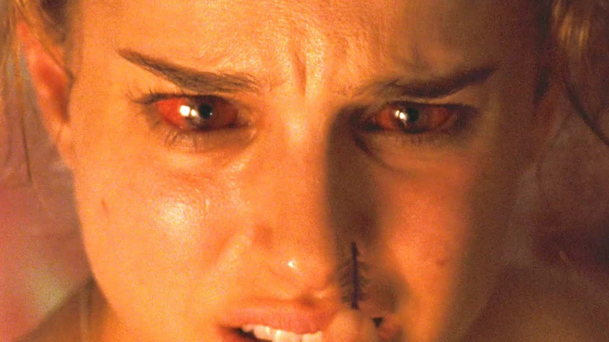 Best lesbian movies #40: A close-up of Natalie Portman with bloodshot eyes as she looks at a feather.