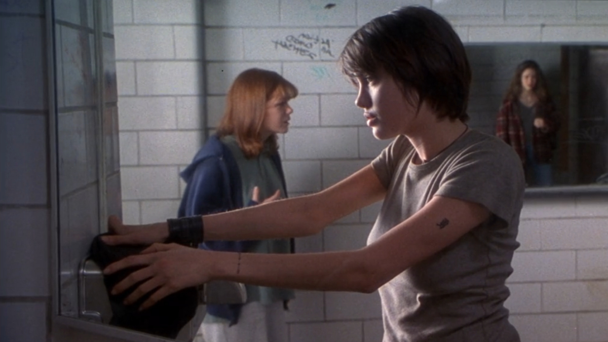 Best lesbian movies #55: Angelina Jolie stands in the girl's bathroom while the other girls argue behind her.