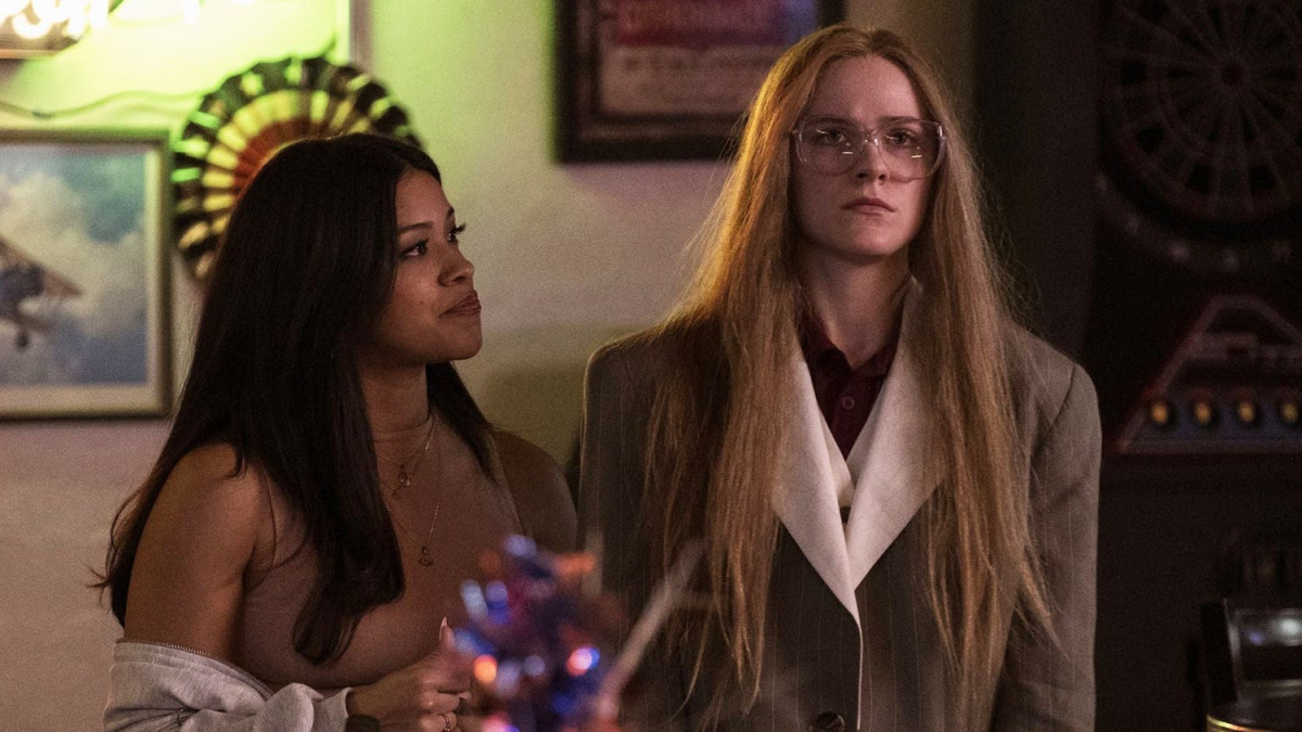 Gina Rodriguez stands next to Evan Rachel Wood in glasses and long straight hair. 