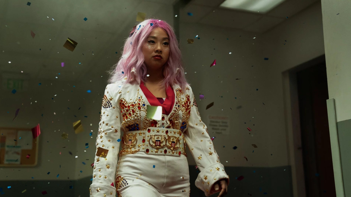 Best lesbian movies #70: Stephanie Hsu dressed in white with a pink wig walks through glitter.