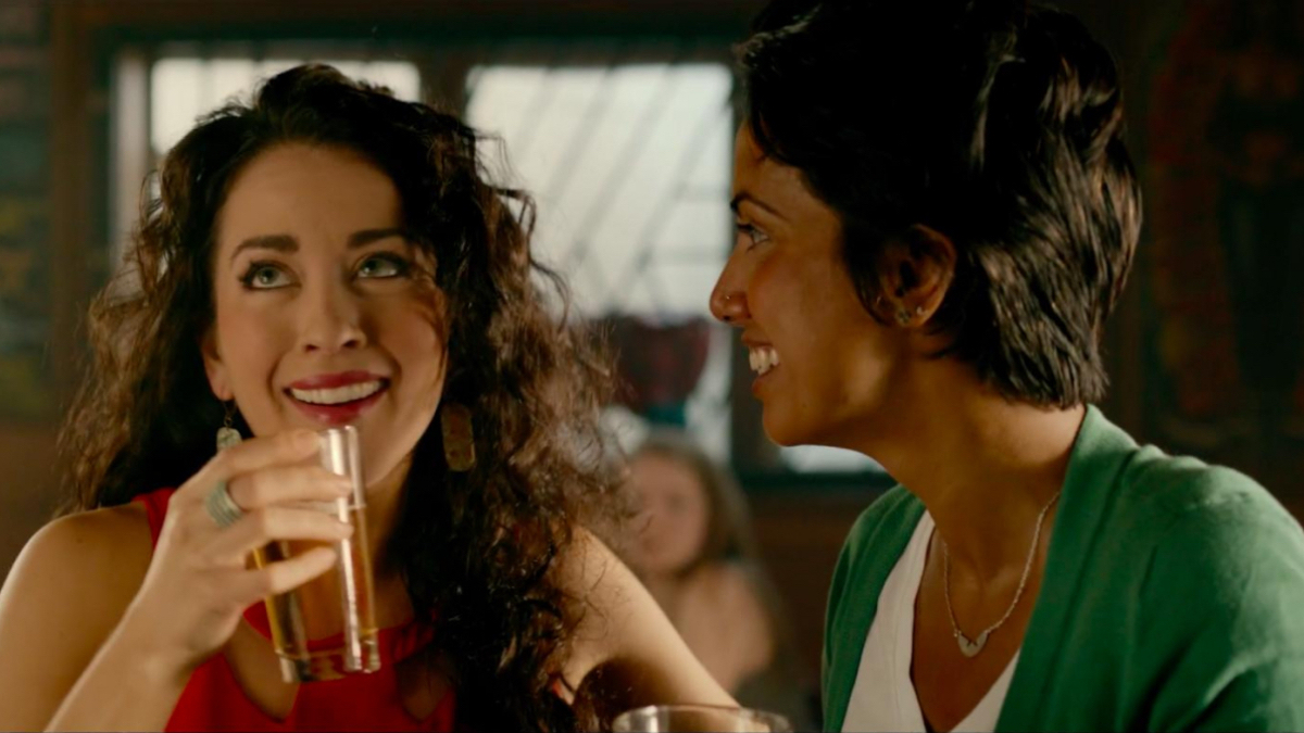 Best lesbian movies #75: Sari Sanchez and Fawzia Mirza laugh at a bar.
