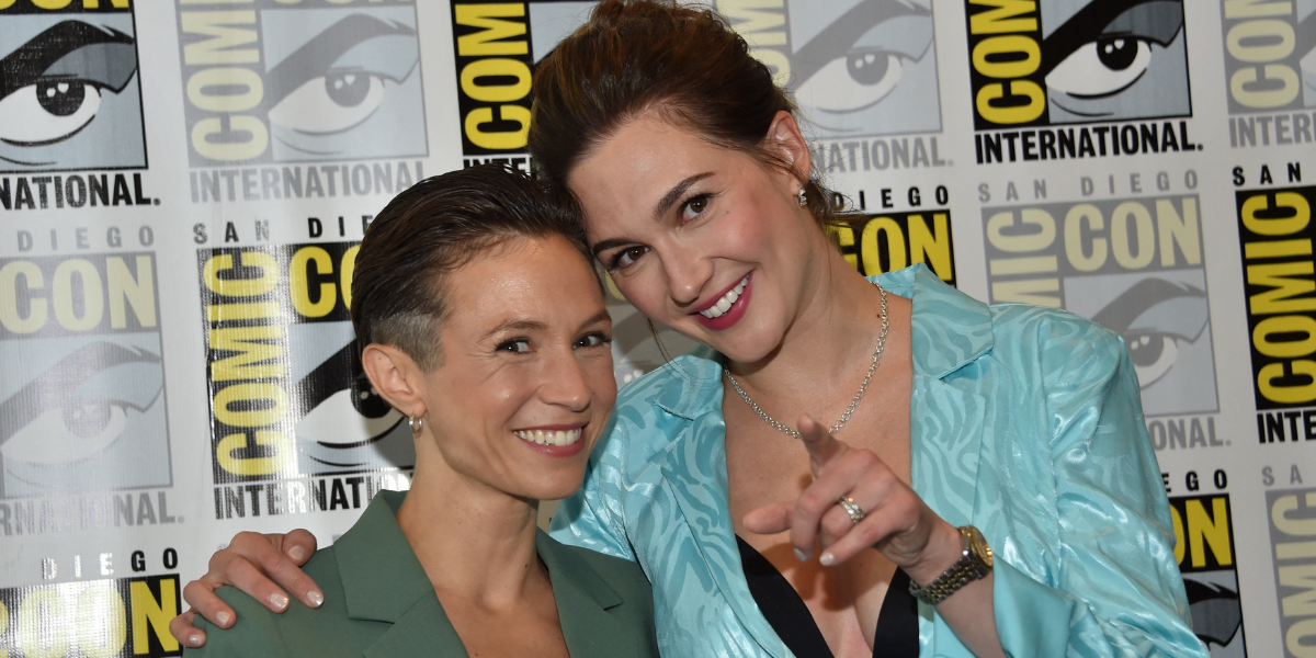 Dom P-C and Kat Barrell at SDCC smiling and pointing at the camera