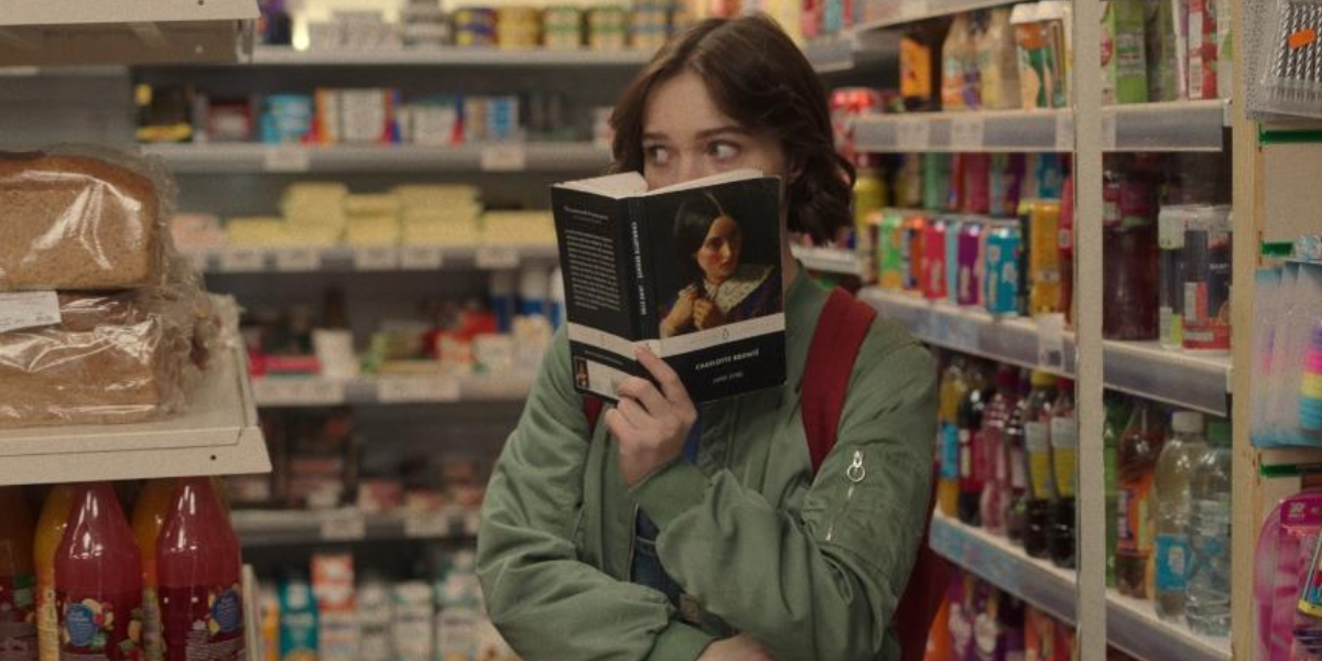 A Good Girl's Guide to Murder: Emma Meyers as Pip hides behind a copy of Jane Eyre