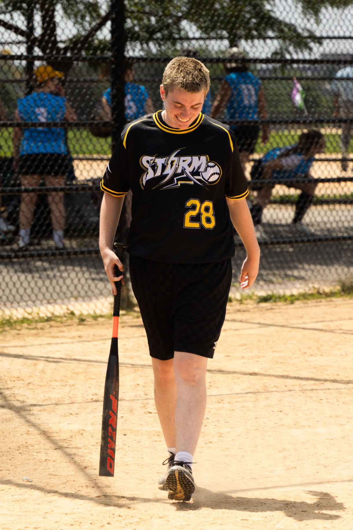 a person in a STORM jersey holds a baseball bat