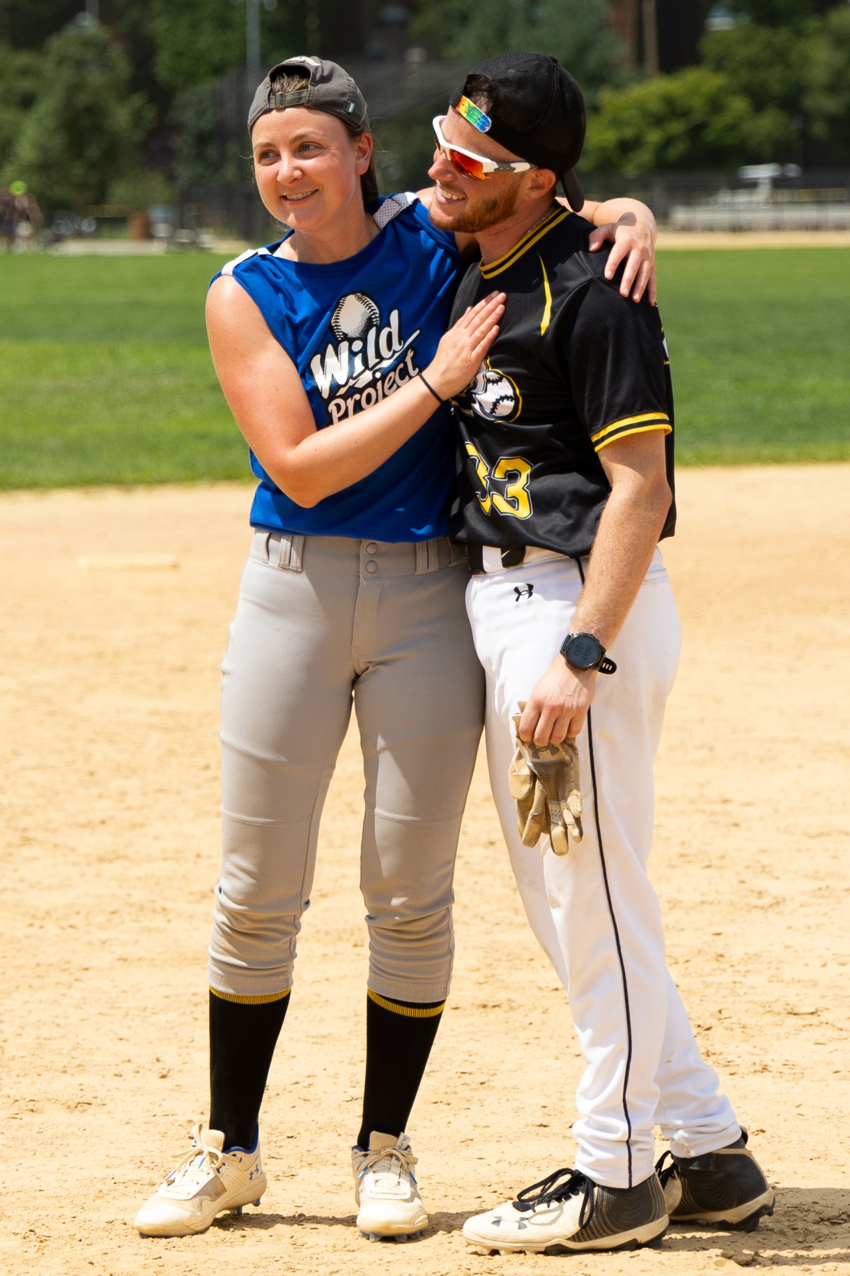 two softball players embrace on the field