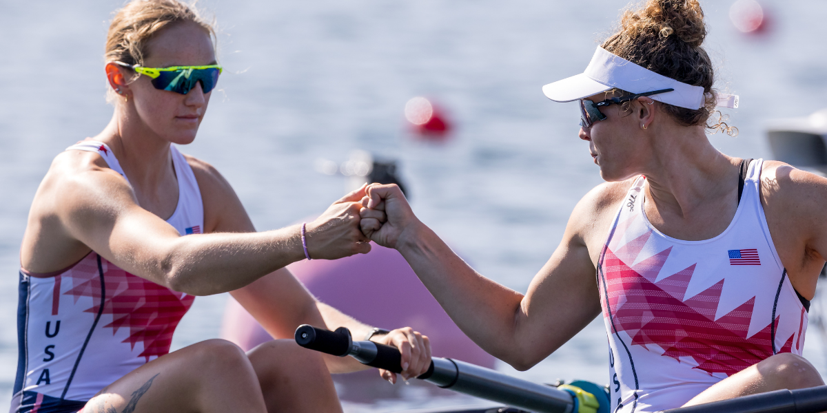 two women from the Olympic rowing team fist bump in the boat