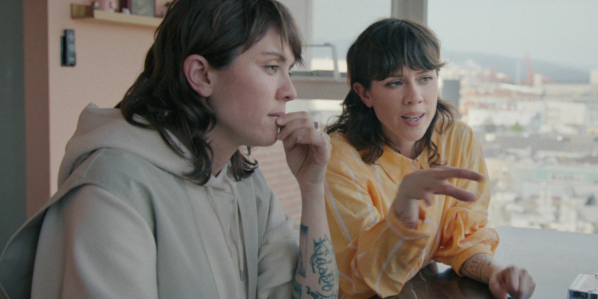 Both wearing sweatshirts, Tegan and Sara give an interview for Fanatical: The Catfishing of Tegan and Sara.