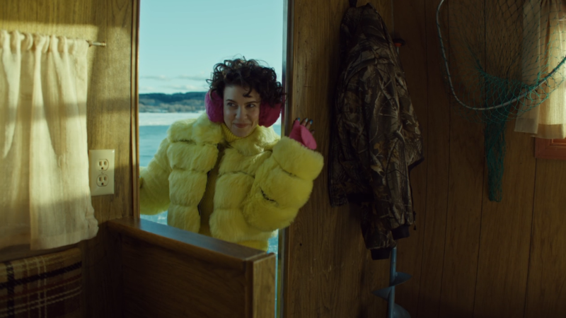 Wynonna Earp Vengeance: Mercedes pokes her head into the fishing hut in a neon yellow puffy coat 