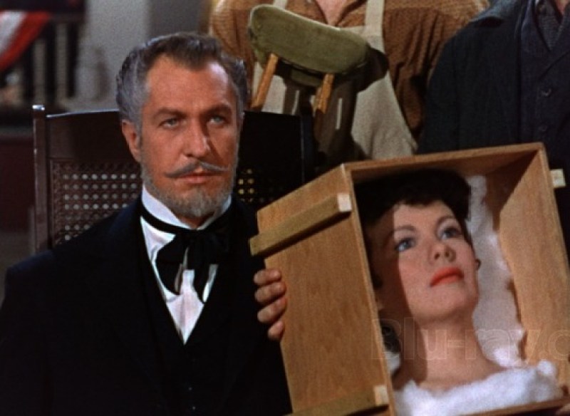 A still from House of Wax of Vincent Price sitting in a chair looking at a wax head in a box.