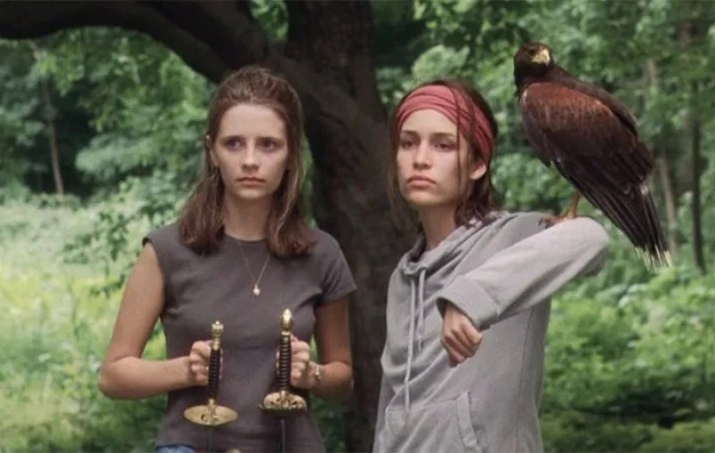 Micha Barton and Piper Perabo in Lost and Delirious. Piper has a falcon on her arm and Micha holds two fencing swords.