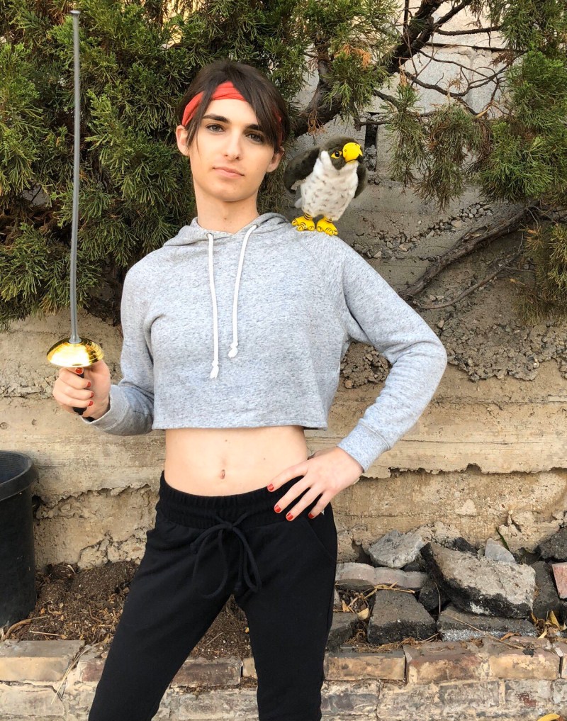 Drew dressed like Piper Perabo in Lost and Delirious with a cropped grey sweatshirt and a stuffed animal falcon