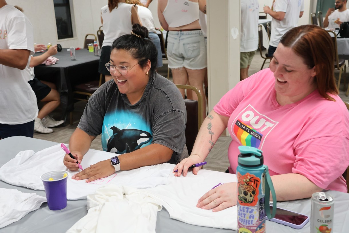 Em and another person at OUTVIVOR making shirts