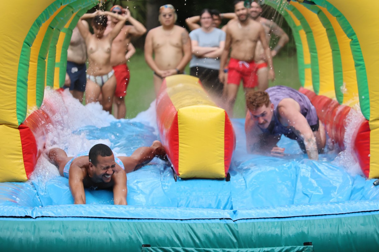 a group of queer people on a slip n slide