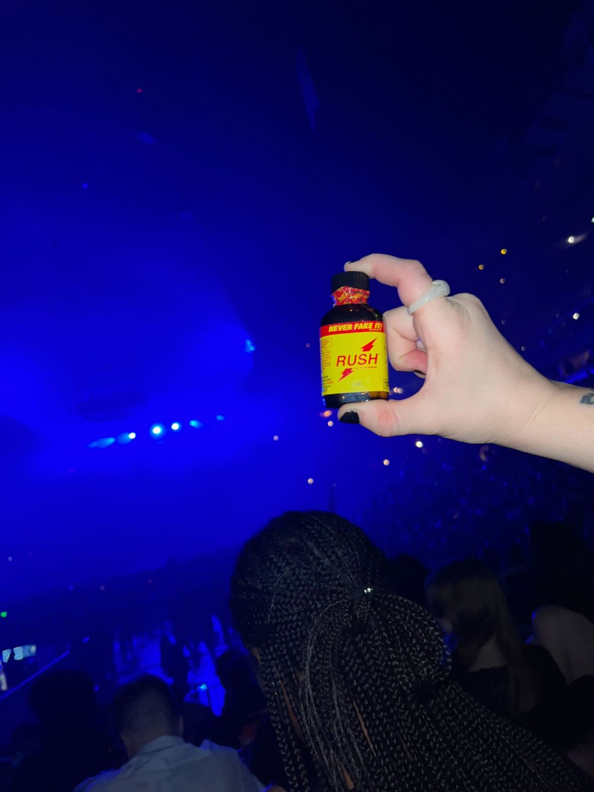 hands holding a bottle of poppers