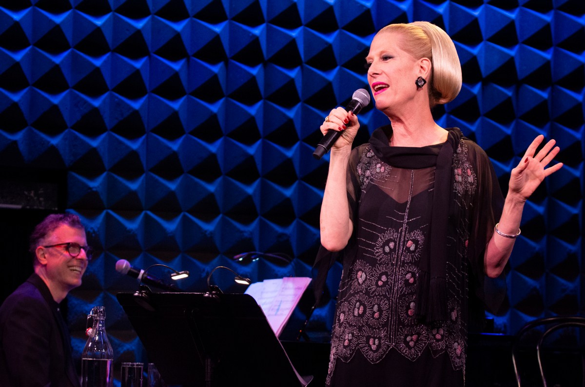 Justin Vivian Bond sings on stage as their pianist smiles at them