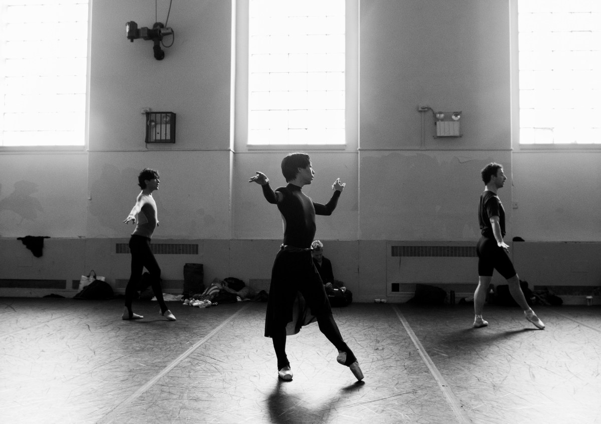 A black and white photo of three dancers in the Trocks in profile. 