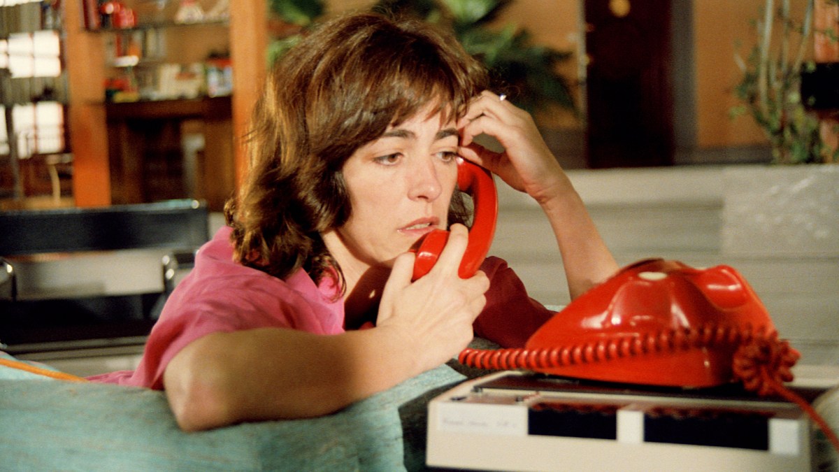 Carmen Maura looks sad as she clutches a red phone.