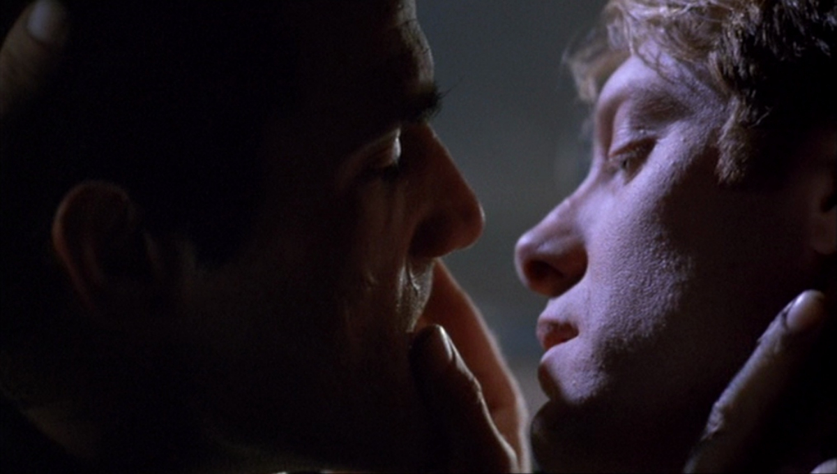 A close up of Elias Koteas and James Spader almost kissing.