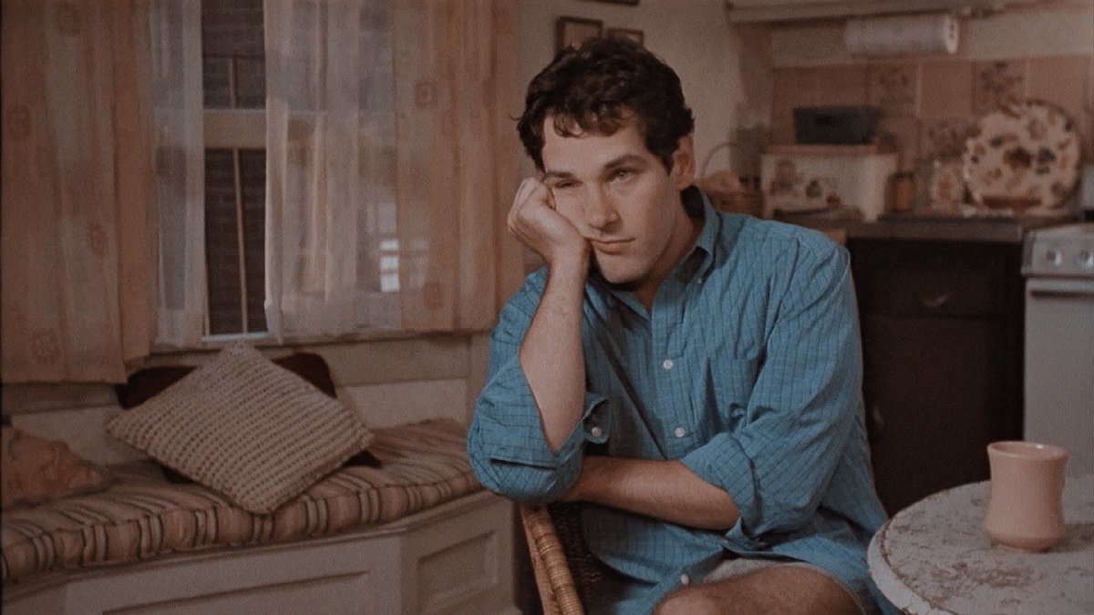 Paul Rudd rests his head on his hand looking annoyed.