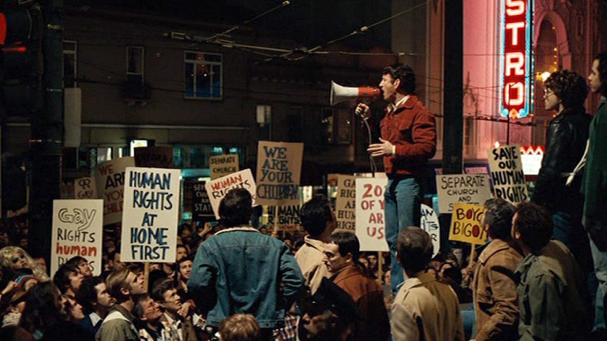 Sean Penn as Harvey Milk speaks through a megaphone to a crowd of protestors.