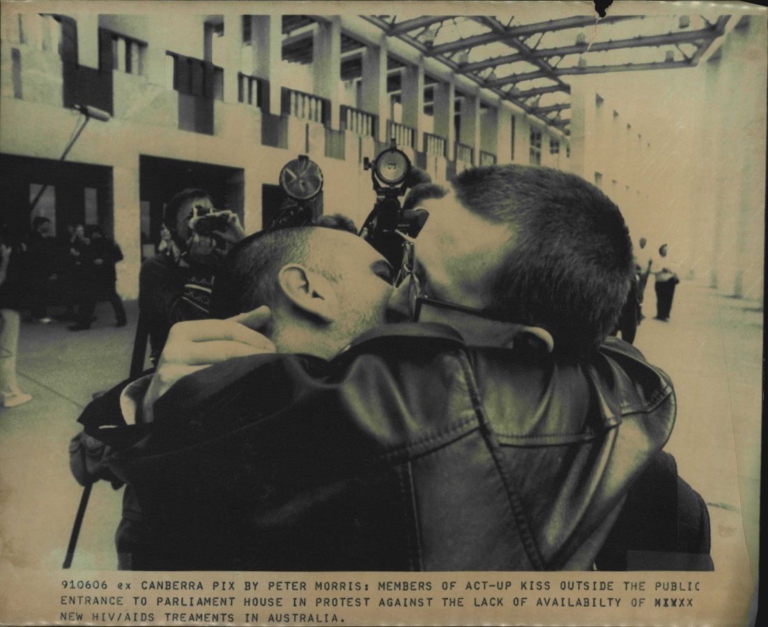 Members of act-up kiss outside the public entrance to parliament house in protest against the lack of availability of new HIV/AIDS treatments in Australia.Men kissed, others staged a "die-in", and two demonstrators jumped from the ***** public gallery in the House of representation to interrupt the Prime Minister ***** yesterday in a protest at delays in getting new anti-AIDS drugs to Australia's ***** 1000 HIV-infected people. Australia protective security service officers at ***** Parliament House seemed particularly incensed by young men kissing. June 6, 1991. (Photo by Peter Morris/Fairfax Media via Getty Images).