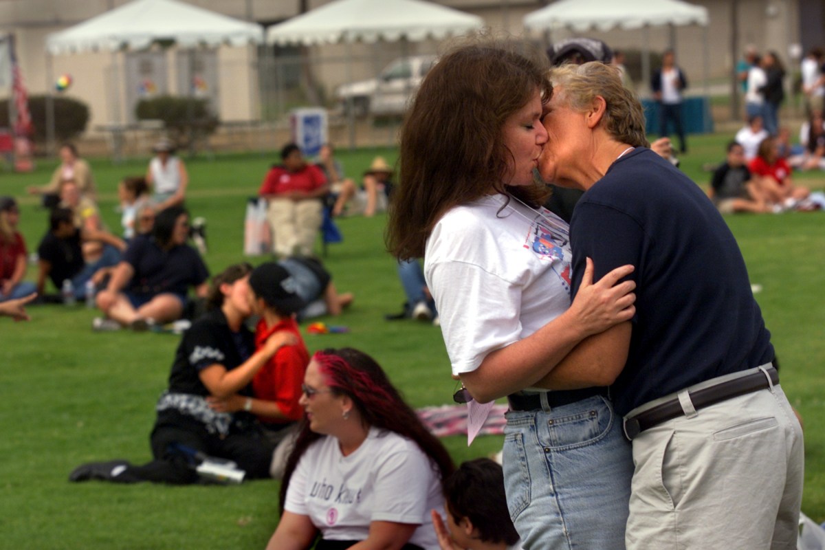 Denise Penn, left in foreground, an advocacy journalist for lesbian news, of San Clemente, kisses Jean Harris, field director for Dean For America (Governor candidate Howard Dean), Saturday during a kissIn at Orange County's first Dyke March at Lions Park in Costa Mesa. The parade aimed to promote social change, celebrate women and fight discrimination, antigay violence and harassment. The event, which began at Lions Park, included live entertainment and women's health information. The march was sponsored by the Gay and Lesbian Community Center. (Photo by Al Schaben/Los Angeles Times via Getty Images)