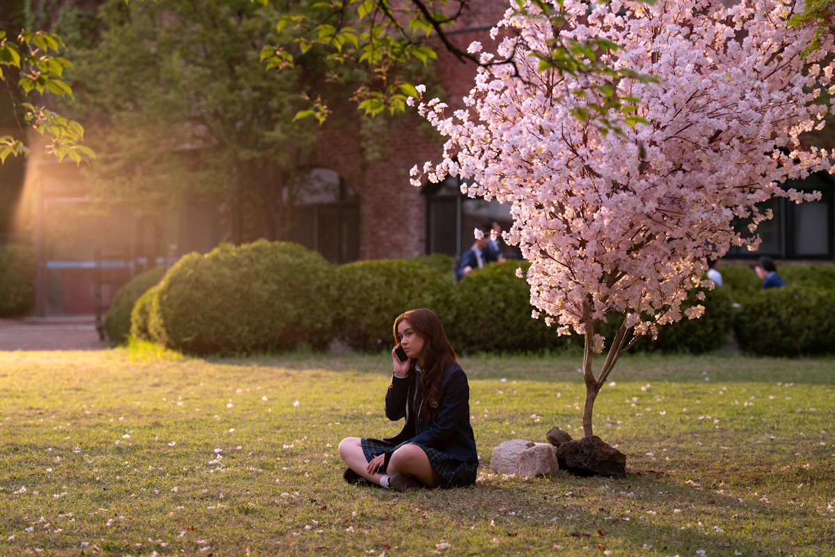 Kitty Song Covey sits beneath her mother's favorite tree on the grounds of KISS.