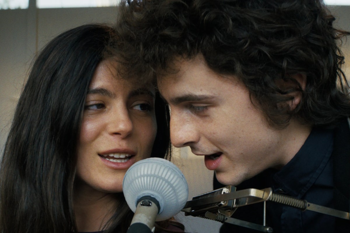 Monica Barbaro and Timothée Chalamet sing together into a microphone