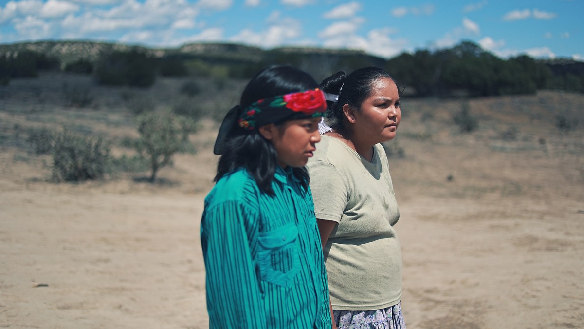 Two Navajo kids stand side by side in the desert