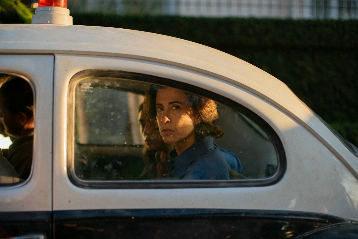 Fernanda Torres looks out a car window face awash with concern