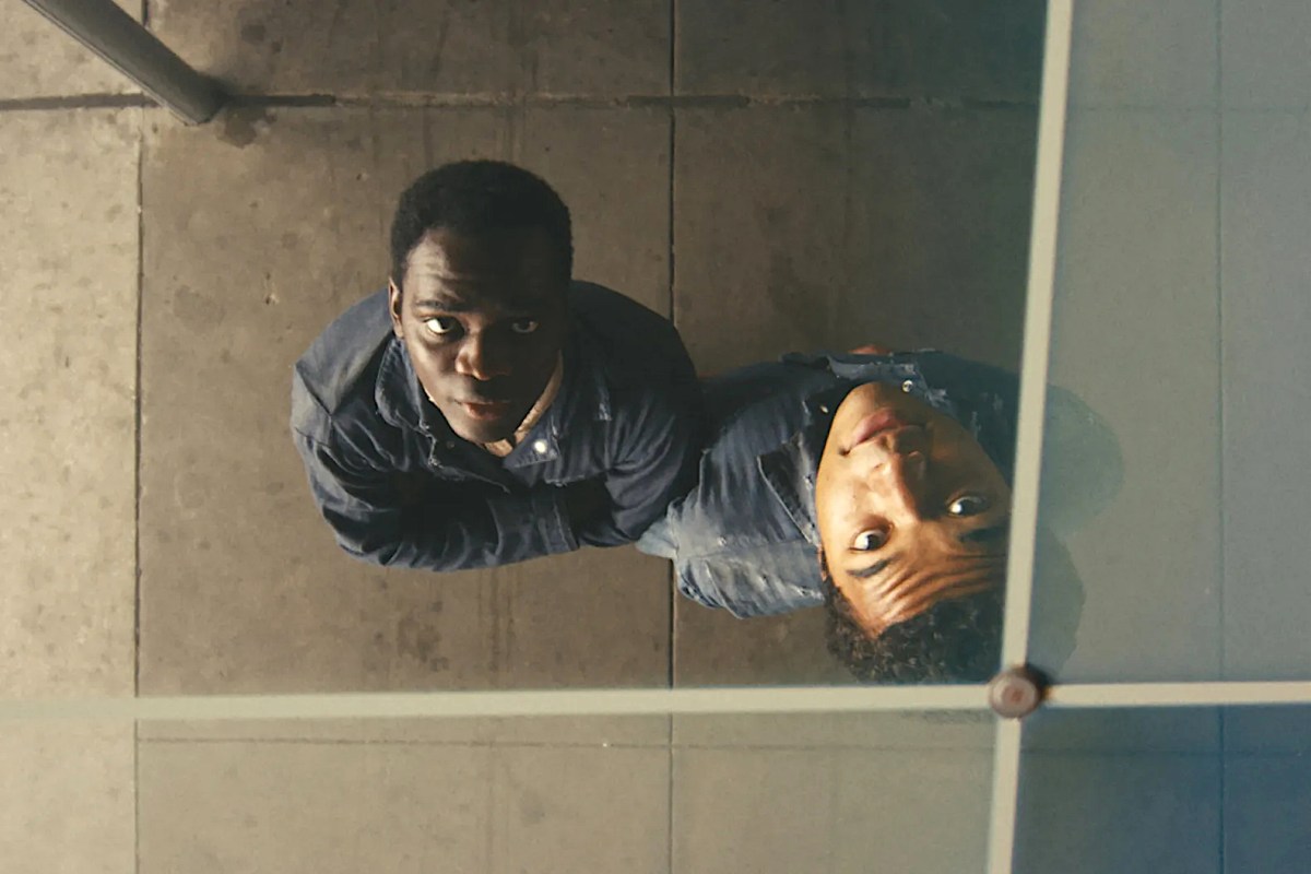 Ethan Herisse and Brandon Wilson look up at their reflection in a ceiling panel.