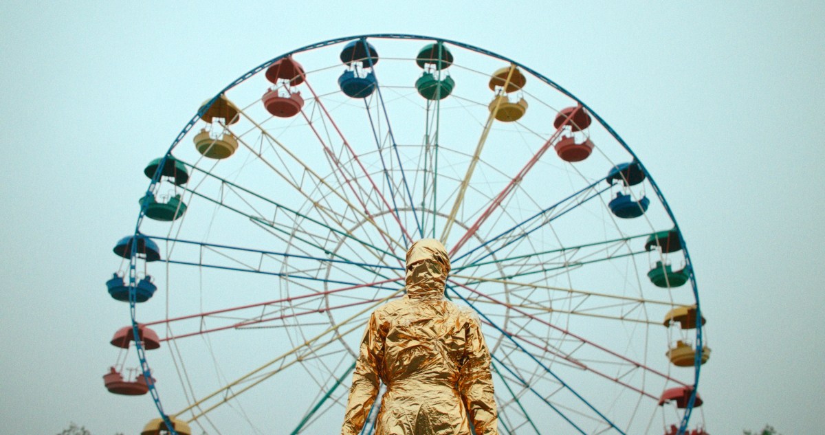 Gena in Queendom in front of a ferris wheel