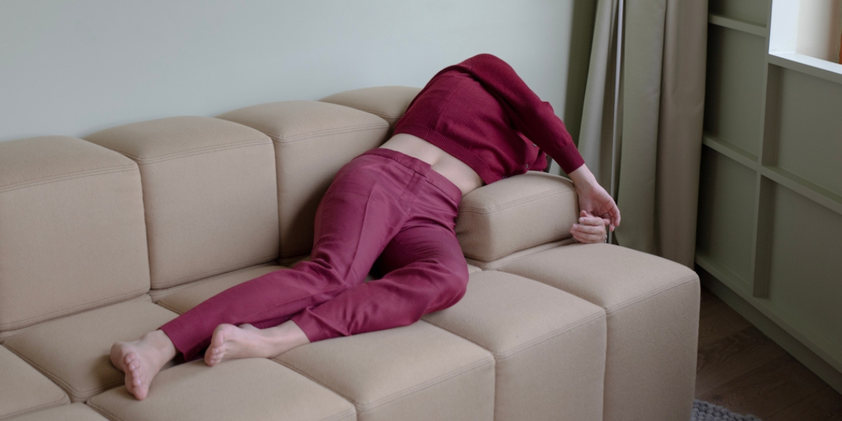 a person flopped over a couch wearing a magenta matching set